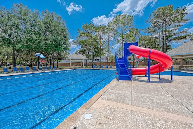 view of swimming pool featuring a water slide and a playground