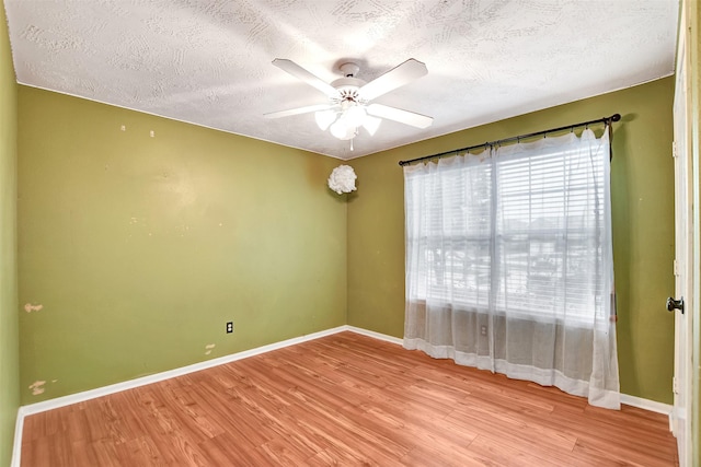 empty room with a textured ceiling, ceiling fan, and light wood-type flooring