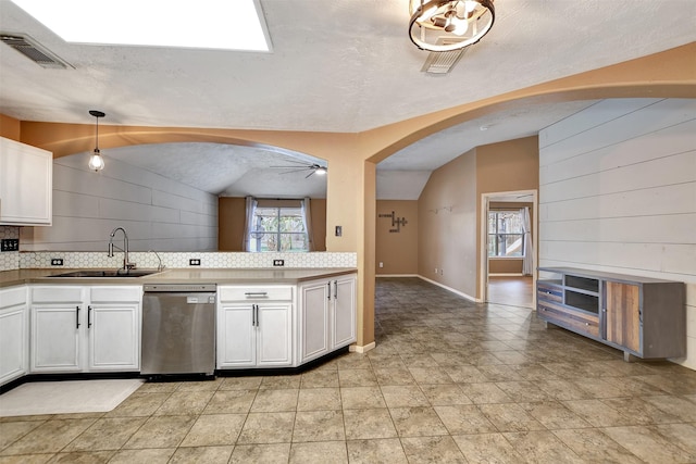 kitchen featuring sink, stainless steel dishwasher, white cabinetry, and hanging light fixtures