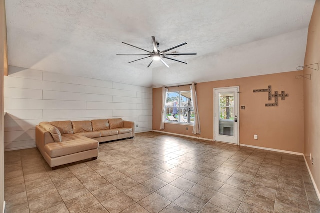 unfurnished living room with a textured ceiling, ceiling fan, lofted ceiling, and light tile patterned floors