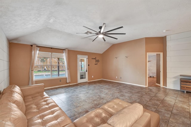 living room featuring ceiling fan, lofted ceiling, and a textured ceiling