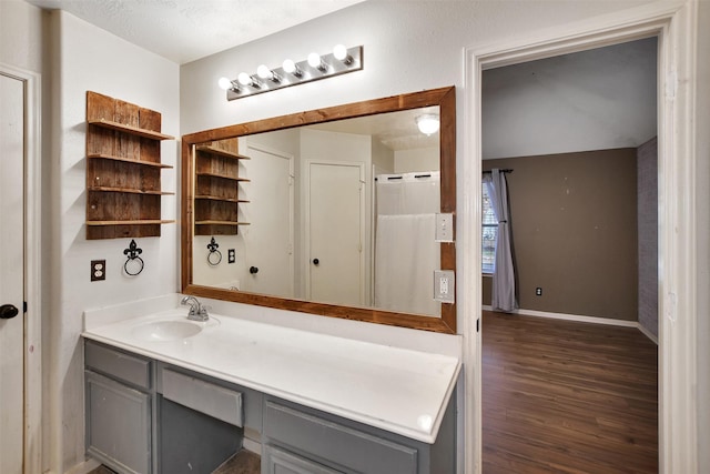 bathroom with a textured ceiling, vanity, and hardwood / wood-style flooring