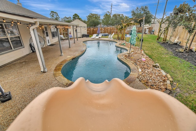 view of pool featuring a lawn and a patio area