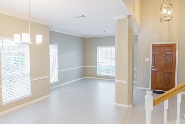 entrance foyer with light hardwood / wood-style floors, a notable chandelier, and crown molding