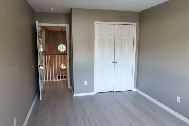 unfurnished bedroom featuring light wood-type flooring and a closet