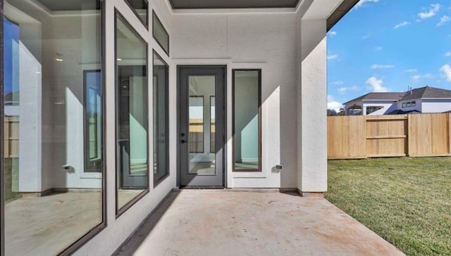 doorway to property featuring a lawn and a patio