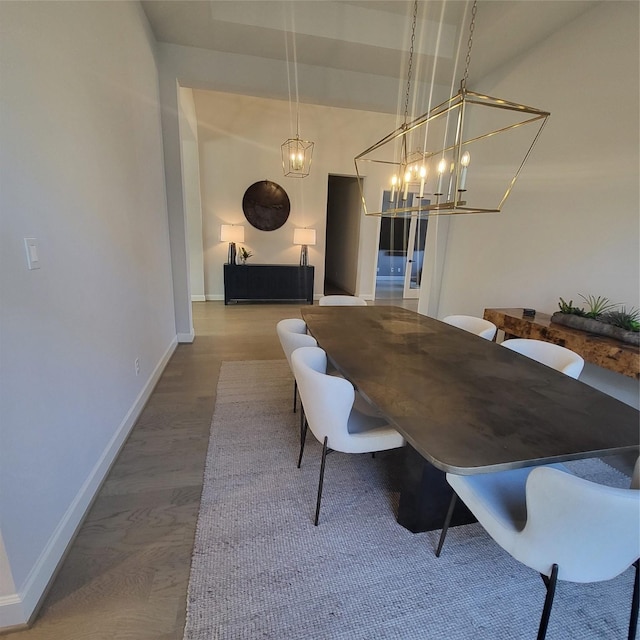 dining space featuring hardwood / wood-style flooring and a notable chandelier