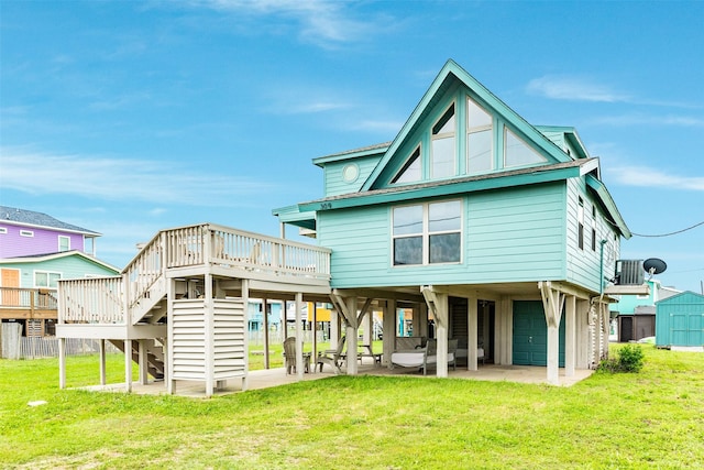 back of property featuring a yard, a garage, and a wooden deck