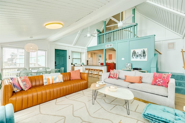 living room featuring visible vents, stairs, lofted ceiling with beams, wood finished floors, and a ceiling fan