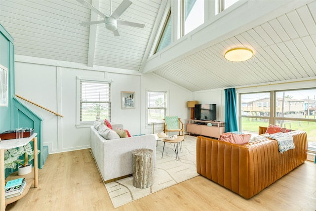 living area with vaulted ceiling with beams, a ceiling fan, and wood finished floors