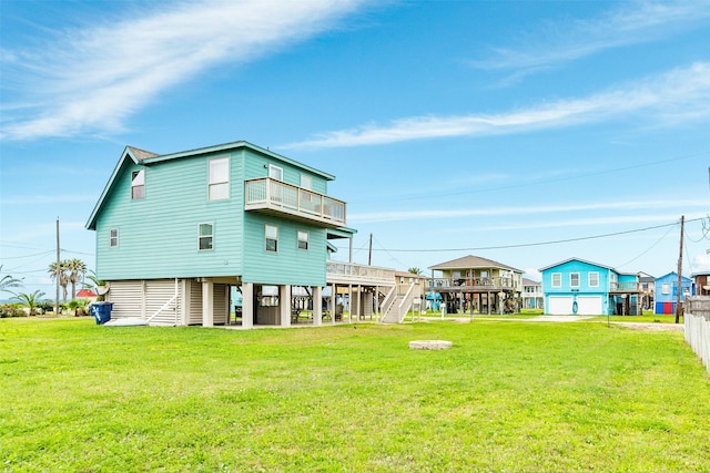 rear view of house featuring a lawn, a balcony, and stairs