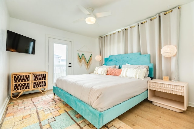 bedroom with access to exterior, wood finished floors, and ceiling fan