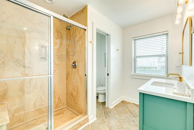 bathroom featuring vanity, toilet, baseboards, and a stall shower