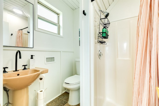 bathroom featuring tile patterned flooring, a shower stall, and toilet