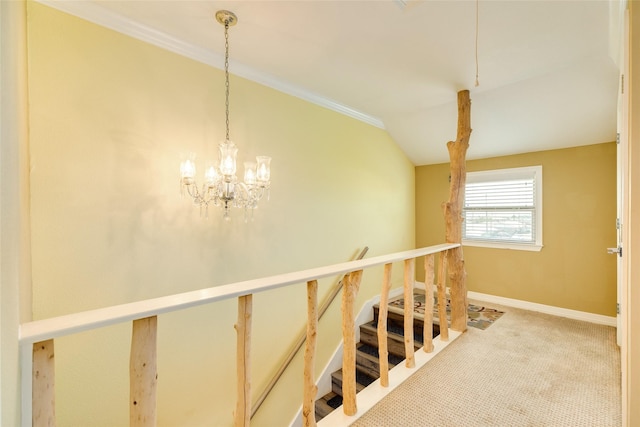 hallway featuring lofted ceiling, a chandelier, crown molding, and carpet flooring