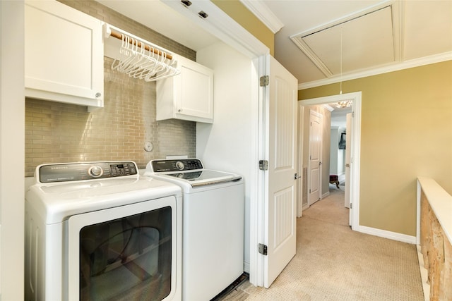 laundry room featuring cabinets, washing machine and clothes dryer, crown molding, and light carpet