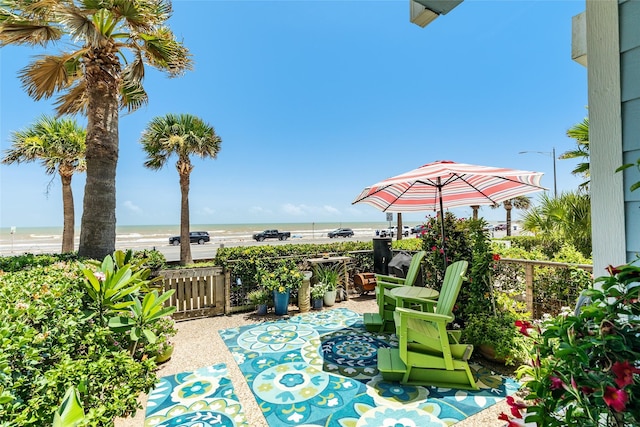 view of patio with a water view and a view of the beach