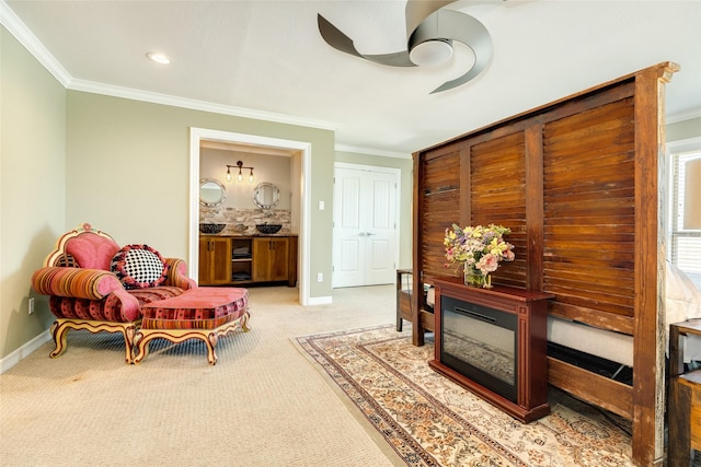 living area with ornamental molding, ceiling fan, and light colored carpet