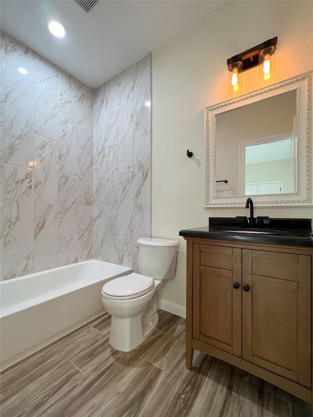 full bathroom with toilet, tiled shower / bath combo, and vanity