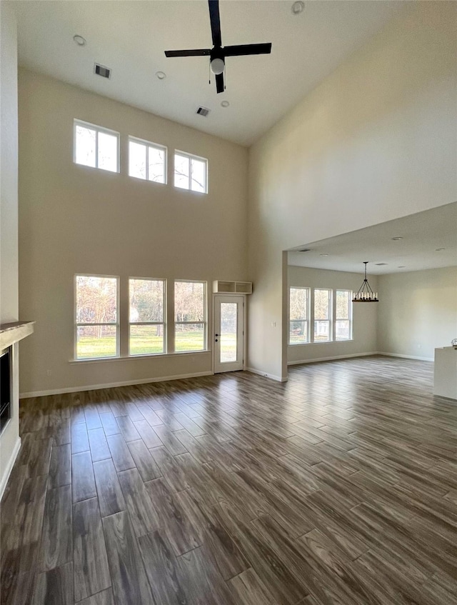 unfurnished living room featuring a towering ceiling and ceiling fan