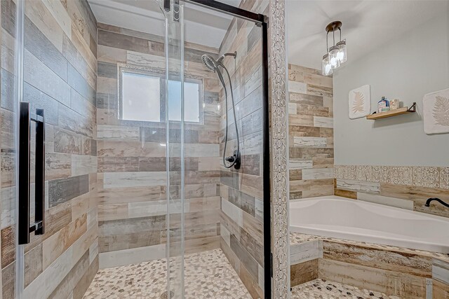 bathroom featuring shower with separate bathtub