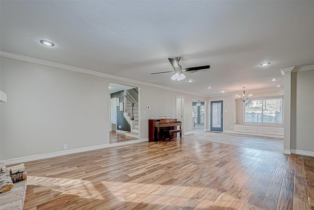 unfurnished living room featuring ornamental molding, light wood-type flooring, and ceiling fan with notable chandelier