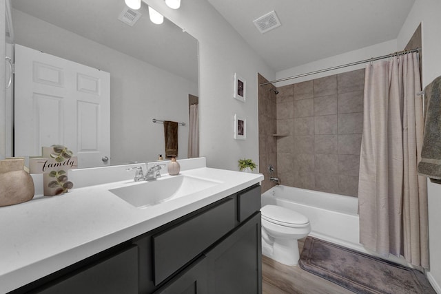 full bathroom featuring hardwood / wood-style flooring, shower / tub combo with curtain, vanity, and toilet