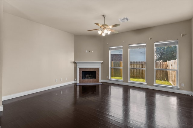 unfurnished living room featuring ceiling fan, dark hardwood / wood-style flooring, and a fireplace