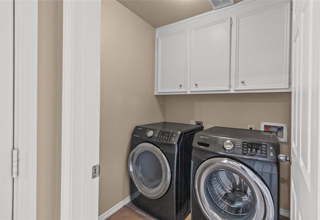 laundry area featuring tile patterned flooring, cabinets, and independent washer and dryer