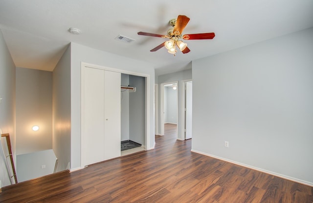 unfurnished bedroom with ceiling fan, dark hardwood / wood-style flooring, and a closet