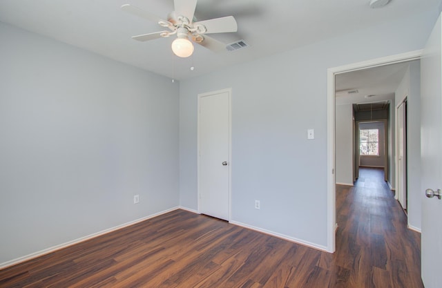 unfurnished room featuring ceiling fan and dark wood-type flooring