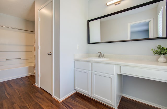 bathroom with hardwood / wood-style flooring, vanity, and shower / bathtub combination with curtain