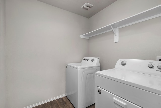 washroom with washing machine and dryer and dark hardwood / wood-style floors