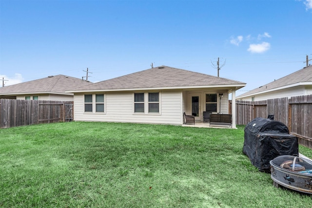 back of house with a patio, a lawn, and a fire pit