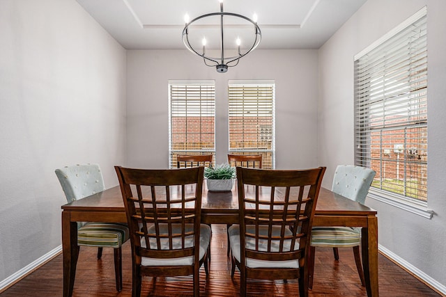 dining room featuring a chandelier, wood finished floors, and baseboards