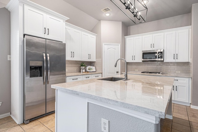 kitchen with a center island with sink, visible vents, white cabinets, appliances with stainless steel finishes, and a sink