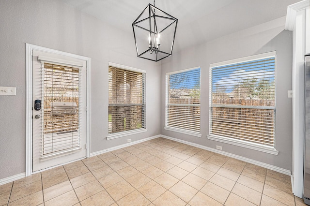 unfurnished dining area featuring a wealth of natural light, light tile patterned floors, baseboards, and an inviting chandelier