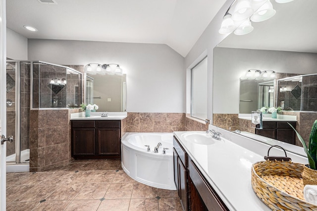 full bathroom featuring vanity, vaulted ceiling, a bath, tile patterned floors, and a stall shower