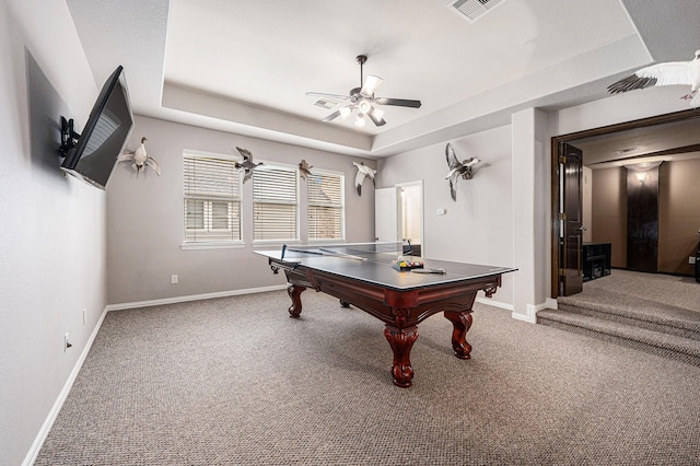 recreation room with ceiling fan, carpet flooring, visible vents, baseboards, and a tray ceiling