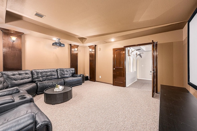 carpeted cinema room featuring visible vents and baseboards