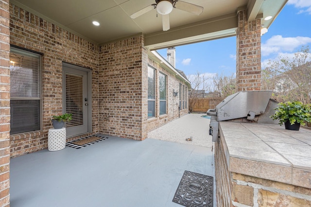 view of patio featuring ceiling fan and fence