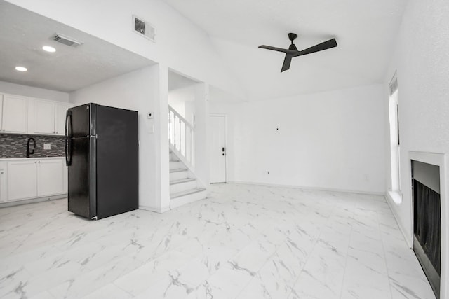 unfurnished living room with ceiling fan and sink