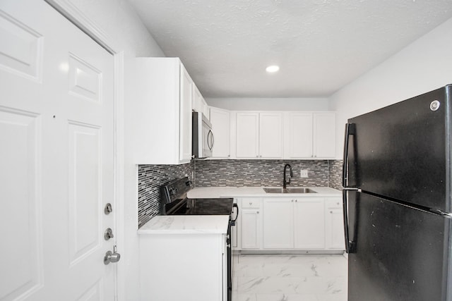 kitchen featuring sink, backsplash, white cabinets, and black appliances