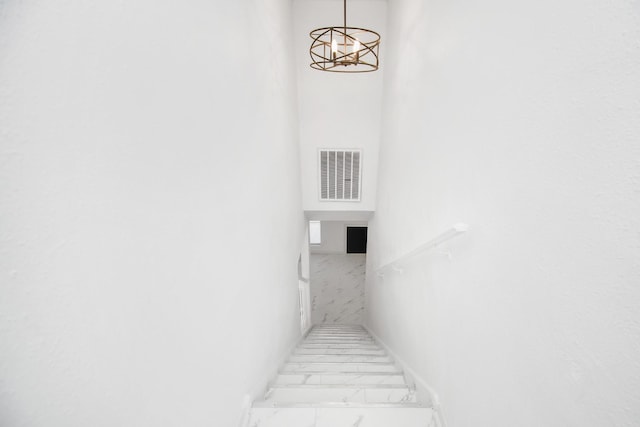 stairs with an inviting chandelier