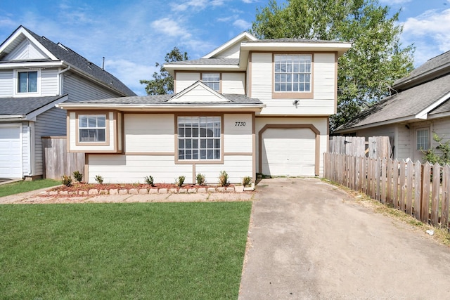 view of front of property with a front yard and a garage