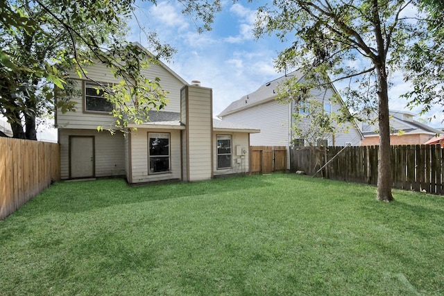 back of house featuring a lawn