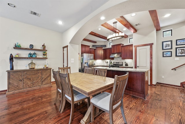 dining area with beam ceiling and dark hardwood / wood-style floors