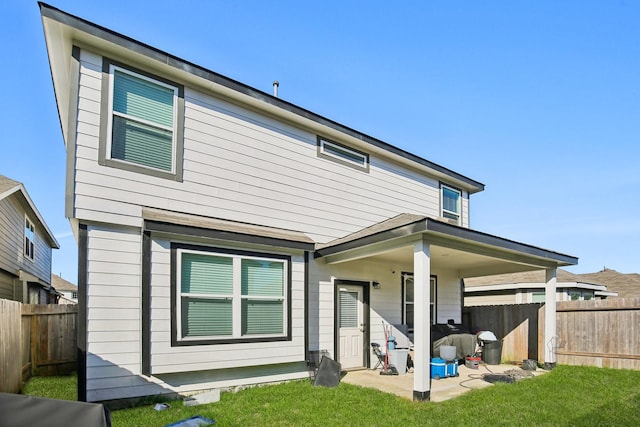 back of property with a lawn and a patio