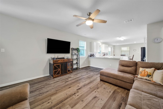 living room featuring hardwood / wood-style flooring, plenty of natural light, and ceiling fan