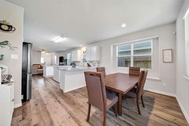 dining room with ceiling fan, a healthy amount of sunlight, sink, and light hardwood / wood-style floors